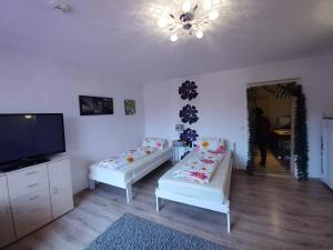 ein Wohnzimmer mit 2 weißen Sofas und einem TV in der Unterkunft Apartment Kati in Ingolstadt
