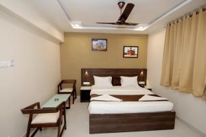 a hotel room with a bed and a desk and a bed at HOTEL SHRINGAR PALACE in Hubli