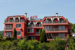 un edificio rojo al lado de una colina en Red Iguana Hotel, en Sveti Vlas