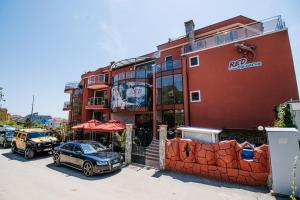 un edificio con un coche aparcado delante de él en Red Iguana Hotel, en Sveti Vlas