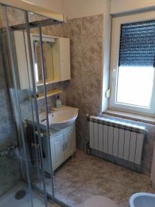 a bathroom with a sink and a glass shower at Jasna rooms in Ilirska Bistrica +17 photos