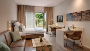 フュルステンフェルトブルックにあるAmper Art Hotelのソファとベッドのあるリビングルーム