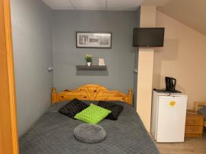 a bedroom with a bed with a green pillow on it at Portoss in Ventspils