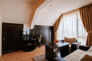 a living room with a couch and a tv at Red Iguana Hotel in Sveti Vlas