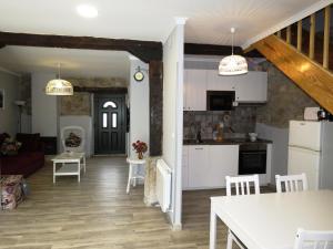 a kitchen and a living room with white cabinets at Casa Rural El Setal. in Villasana de Mena