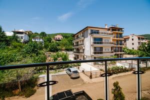 a balcony with a car parked in a parking lot at Red Iguana Hotel in Sveti Vlas