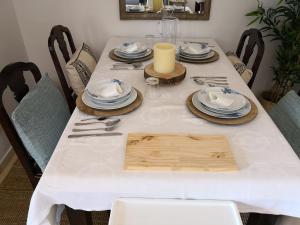 エステポナにあるCostalita del Solのダイニングルームテーブル(白いテーブルクロス、皿、銀製品付)