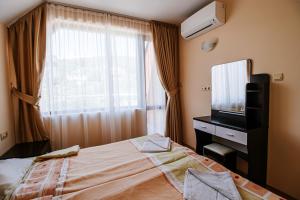 a hotel room with a bed and a television at Red Iguana Hotel in Sveti Vlas +98 photos