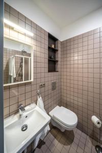 a bathroom with a white toilet and a sink at Hotel Saida - quality hostel in Riga