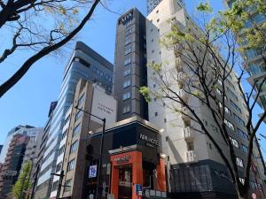 
a tall building with a clock on the side of it at APA Hotel Shibuya Dogenzakaue in Tokyo
