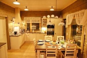 a kitchen with a table and chairs in a kitchen at Luxury lakeside house on Saimaa in Punkaharju