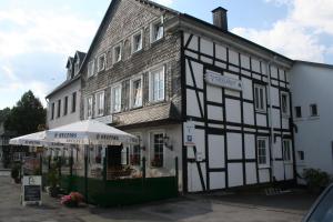 um velho edifício preto e branco com um guarda-chuva em Grillglut em Arnsberg