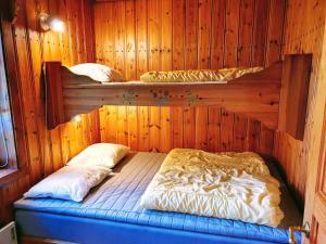 a room with two bunk beds in a wooden wall at Klarälvsbyn in Sysslebäck