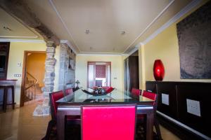 比拉加爾西亞德亞羅薩的住宿－Casa Cotón - Chalet vacacional de playa，一间带桌子和红色椅子的用餐室