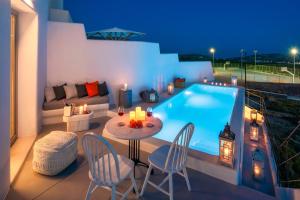 a patio with a table and chairs next to a swimming pool at MILESTONE VILLAS in Megalochori