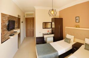 a hotel room with a bed and a tv at Papirus Hotel in Adrasan