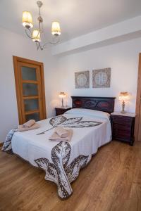 a bedroom with a large bed and two night stands at Pensión Casa do Gallo Sarria in Sarria
