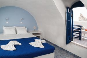 佩里萨Roula Villa Studios & Apartments的一间卧室，床上有一张带毛巾的床