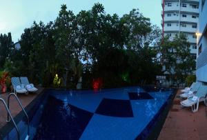 a swimming pool with chairs next to a building at Hotel Sapphire in Colombo
