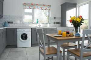 una cucina con tavolo e lavatrice di Bramble Cottage a Rathfriland