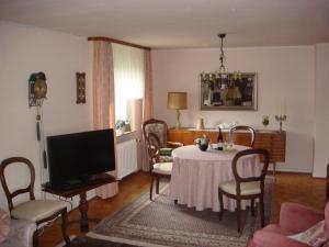 un soggiorno con tavolo e TV di Ferienwohnung Trier a Treviri