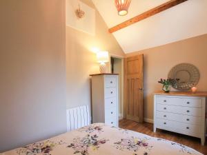 a bedroom with a bed and a dresser and a drawer at Little Bakehouse in Criccieth