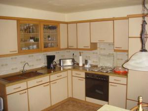 a kitchen with white cabinets and a sink and a stove at Ferienwohnung Trier in Trier