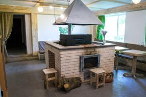 a living room with a brick fireplace with a hood at Baron Munchausen Guest House in Kamianets-Podilskyi
