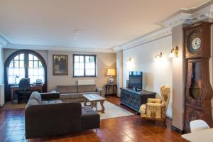 a living room with a couch and a tv at Apartamentos Capriccio in Santillana del Mar