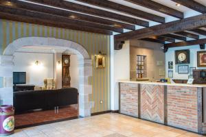 a room with a counter with a clock on the wall at Apartamentos Capriccio in Santillana del Mar