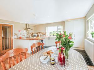 a kitchen and dining room with a table and chairs at Coed Bolyn Lodge in Llanddeiniolen