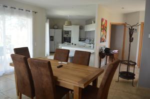 cocina y comedor con mesa de madera y sillas en Villa en Combas