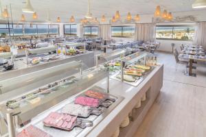a restaurant with a buffet line with food on display at Zahara Beach & Spa by QHotels - Adults Recommended in Zahara de los Atunes