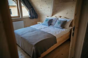 a bedroom with a bed in a log cabin at Osada Witów - dom "Miłosna Górska" in Witów