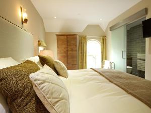 a bedroom with a large white bed with pillows at Harlech Apartments - Matholwch in Harlech