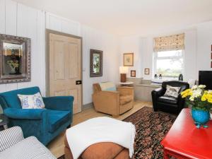 a living room with blue chairs and a couch at Big House in Llandecwyn