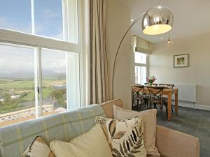 a living room with a couch and a table and a window at Harlech Apartments - Branwen in Harlech