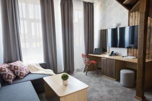 a living room with a couch and a desk at Hotel Central in Ruse