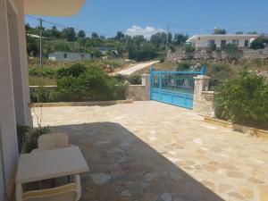 a patio with a blue gate and a road at Guesthouse Emanuel in Ksamil