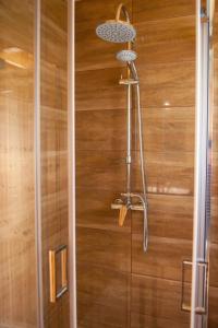 um chuveiro na casa de banho com uma parede de madeira em Domki Zagroda Domek z bala z basenem em Słopnice