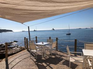 un tavolo e sedie su una terrazza con vista sull'acqua di Apartamentos Llevant a Ibiza Città