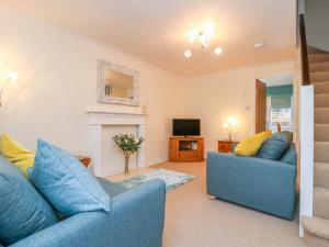 ein Wohnzimmer mit zwei blauen Sofas und einem TV in der Unterkunft 17 Fewster Way in York