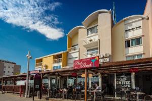 personas sentadas en mesas fuera de un edificio en Hôtel Port Beach, en Gruissan