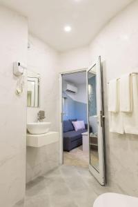 La salle de bains est pourvue d'un lavabo, de toilettes et d'un miroir. dans l'établissement Hotel Central, à Ruse