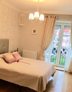 a bedroom with a bed with pink pillows and a window at VUT - Mirador de la Catedral in Burgos