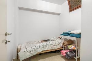 Cette petite chambre comprend un lit et une étagère. dans l'établissement Zeewende 1A, à Zeebruges