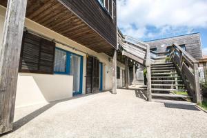 eine Treppe, die zu einem Gebäude mit blauen Türen und Fenstern führt in der Unterkunft LE SOLEIL DE JADE village vacances in Préfailles