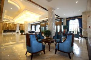 a lobby with chairs and a table in a building at Zhangye Kerry Hotel in Zhangye