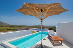 a large umbrella over a swimming pool on top of a house at MILESTONE VILLAS in Megalokhori