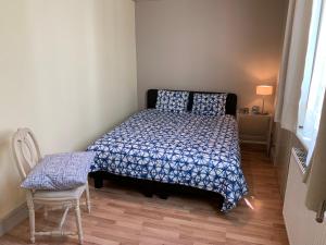 a small bedroom with a bed and a chair at Babelle 1 in Blankenberge